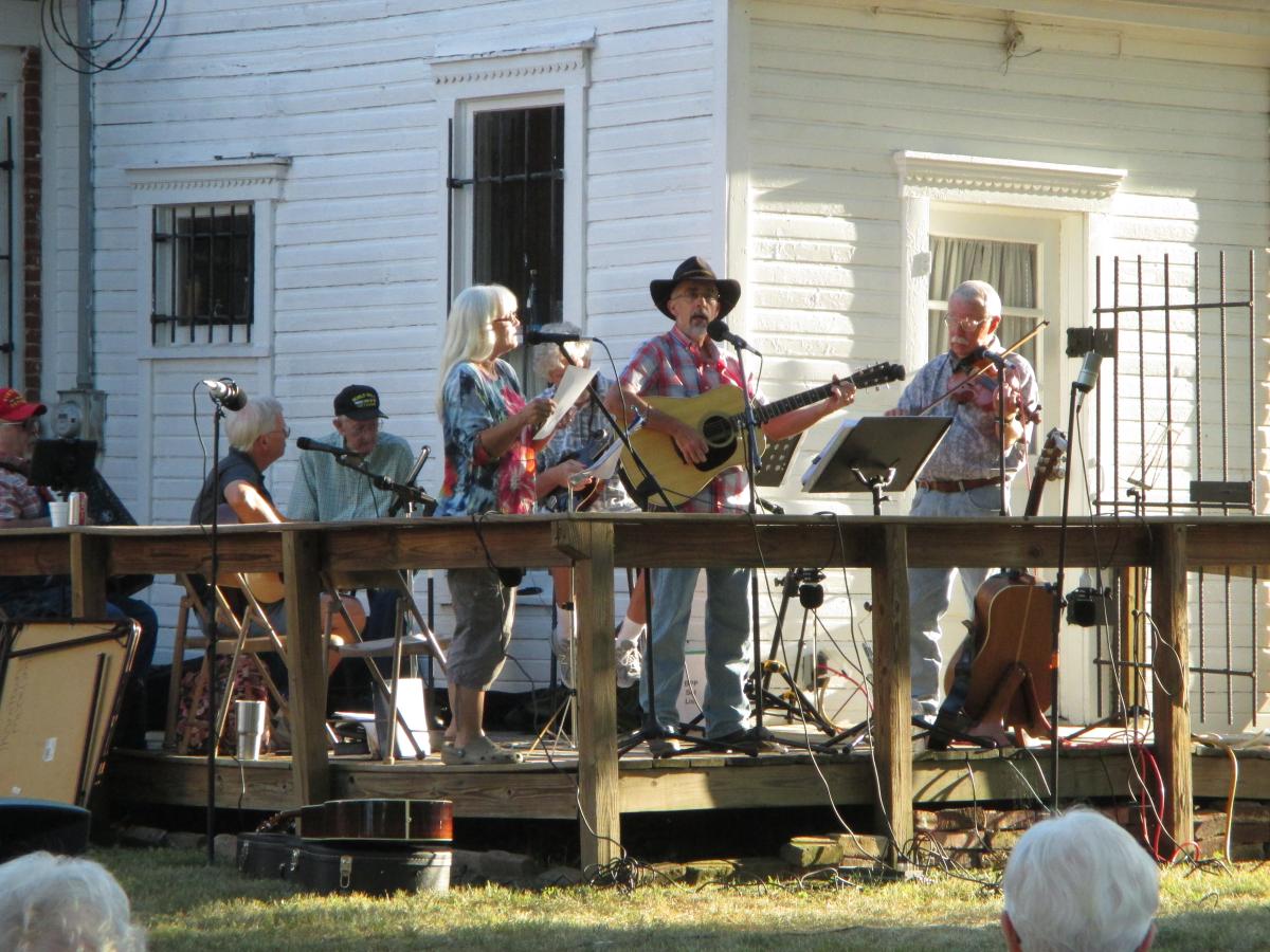 photo of Thorntown Bluegrass Jammers playing on the back porch of the museum